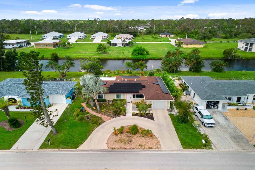 Aerial view of the Rotonda residential area with homes surrounding a pond, showcasing varied roofing and landscaped yards.